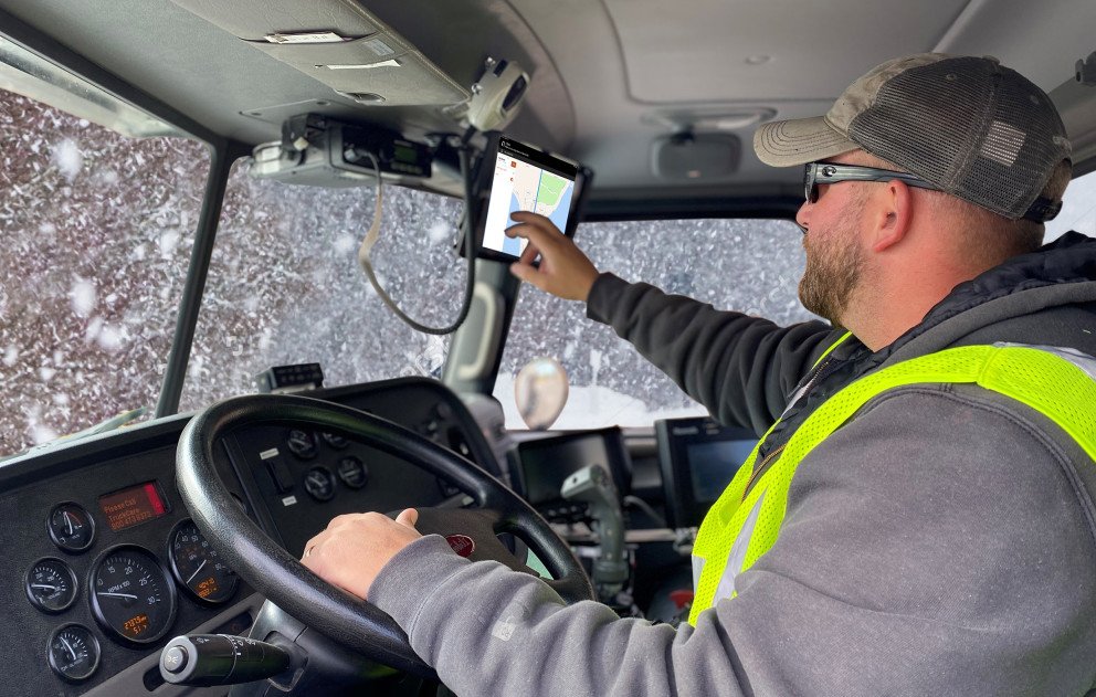 Snowplow Truck Interior with Driver Using GIS in Snowstorm